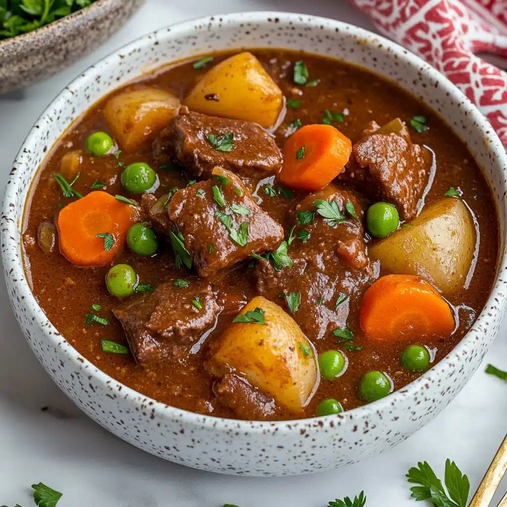 This close-up image shows a bowl of thick beef stew with chunks of tender brown beef, bright orange carrot pieces, small green peas, and yellow potato chunks all mixed in a rich brown sauce. A silver fork holds a piece of soft beef with some fibers showing, lifting it slightly above the stew surface. There are small fresh green herb leaves floating on top as garnish. The bowl is white with a speckled design, sitting on a white marbled surface. photo taken with an iphone--v 6.1