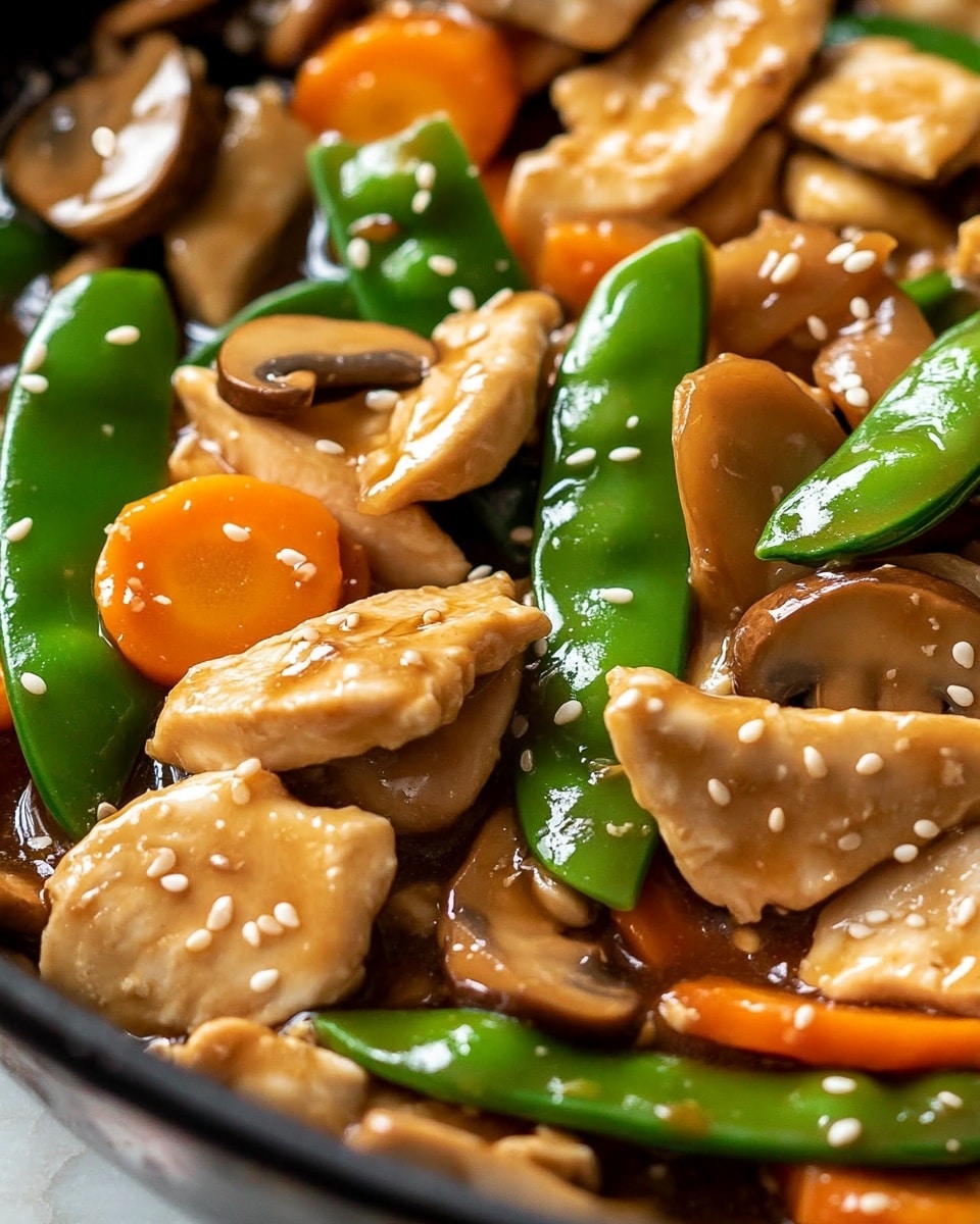This image shows a close-up of a stir-fry dish in a pan. The dish has three main layers: the bottom layer is a shiny light brown sauce that coats everything. The middle layer has tender light brown chicken pieces scattered evenly. The top layer is made of bright green sugar snap peas, orange carrot slices, light beige water chestnuts, and sliced brown mushrooms. The dish is sprinkled with small tan sesame seeds all over. The background shows a white marbled texture. Photo taken with an iphone --ar 4:5 --v 6.1