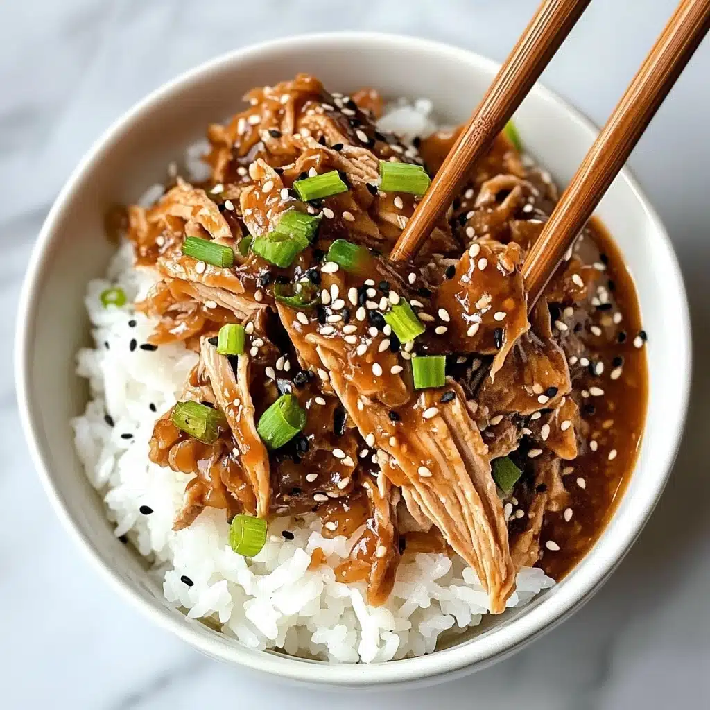 A white bowl filled with a base layer of white cooked rice topped with chunks of brown shredded meat in a sticky sauce. The meat is sprinkled with small black and white sesame seeds and garnished with small pieces of green onion. A pair of wooden chopsticks held by a woman's hand is lifting some meat above the bowl. The background is a white marbled texture. Photo taken with an iphone--v 6.1