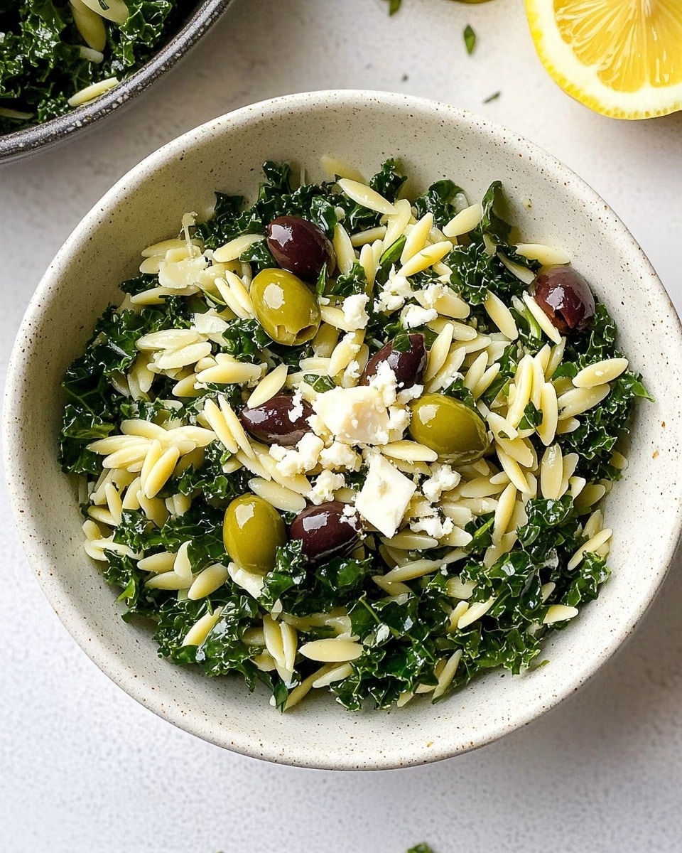 A green bowl holds a salad made of three main layers: the bottom layer is dark green leafy vegetables, the middle layer consists of pale yellow orzo pasta pieces mixed throughout, and the top layer includes small white cheese crumbles and scattered green pumpkin seeds, with one dark purple olive near the center. A black fork rests inside the bowl, slightly inserted into the salad. The bowl sits on a white marbled surface, and a yellow and white patterned cloth is placed behind the bowl. Photo taken with an iphone --ar 4:5 --v 6.1