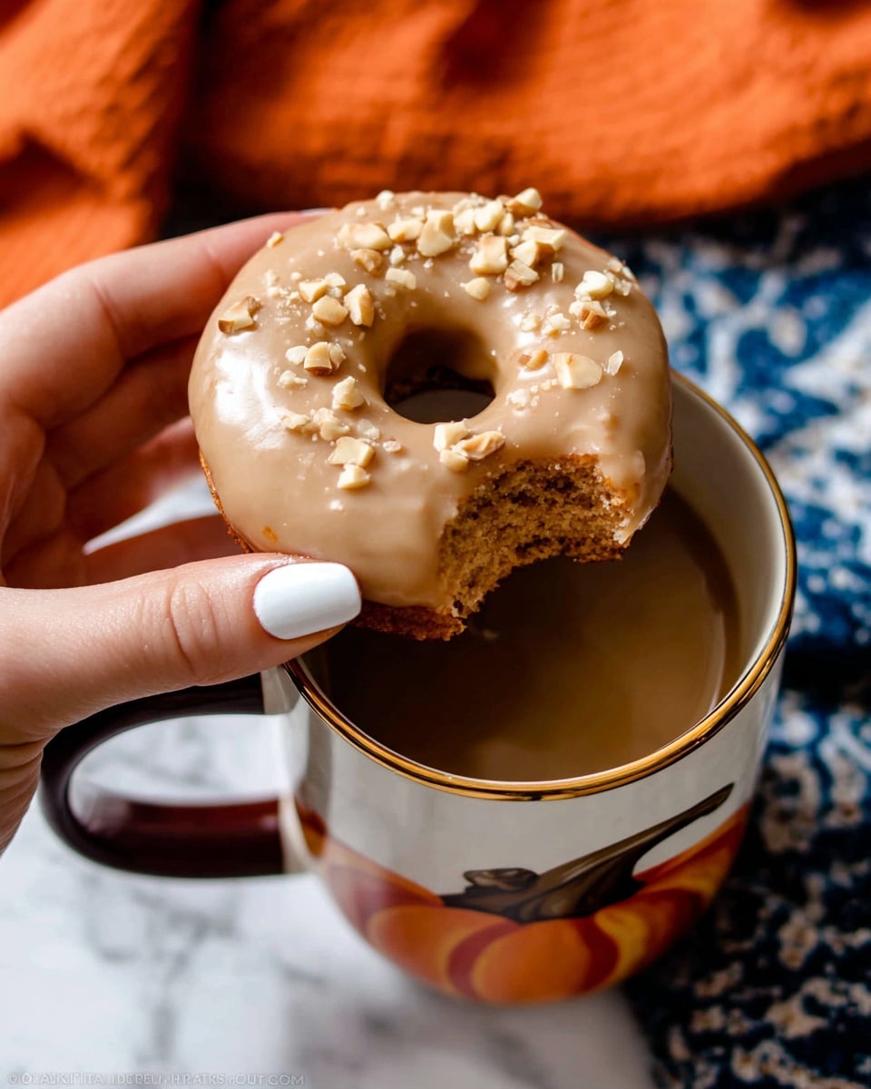 A stack of three round donuts with a light brown color and a soft, crumbly texture, each topped with a smooth, creamy white icing. The top donut has a bite taken out, showing the fluffy inside and the thickness of the donut. Small white crumbs are sprinkled on the icing. The donuts sit on a red cloth on a surface with a white marbled texture. Another donut with the same icing is sitting close by on the right side. Photo taken with an iphone --ar 4:5 --v 7