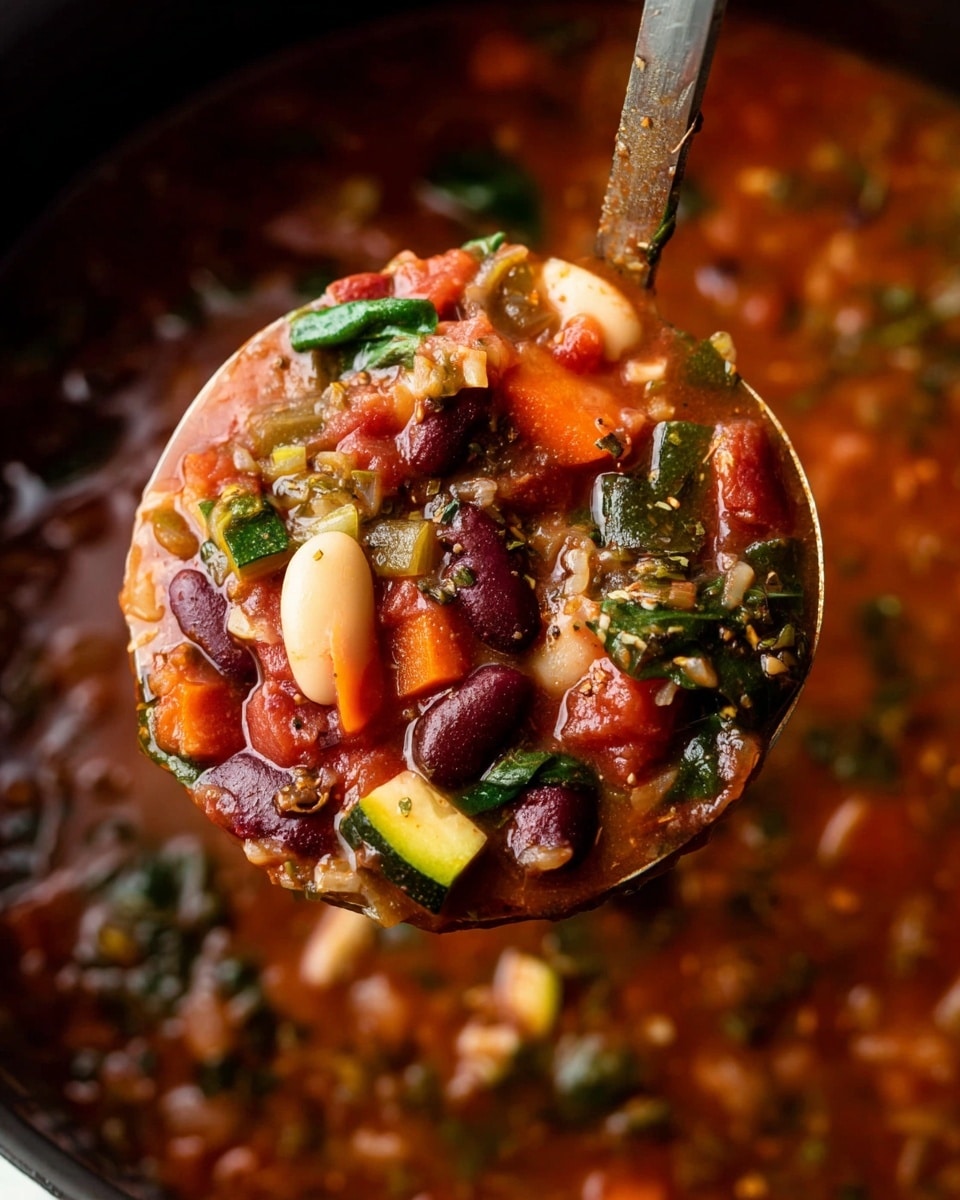 A close-up of a ladle full of thick vegetable soup lifted above a pot, showing layers of rich red broth mixed with visible ingredients including dark red kidney beans, large white beans, bright orange carrot pieces, chopped green spinach leaves, and chunks of light green zucchini, all floating in a textured, hearty tomato-based liquid. The soup has a chunky texture with small bits of herbs and spices scattered throughout. The background features the same white marbled texture under the pot. photo taken with an iphone --ar 4:5 --v 7