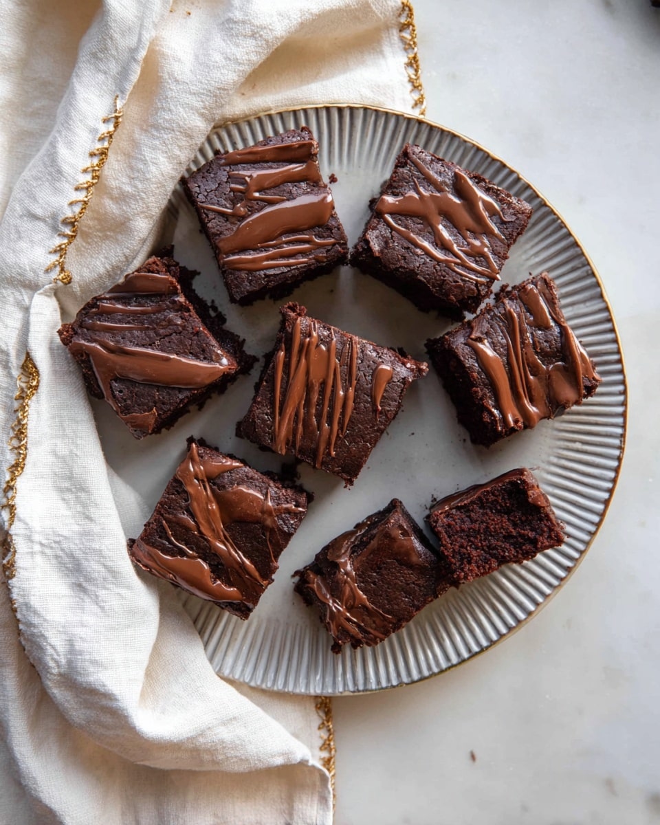 The image shows a round white plate with a ridged texture holding eight square pieces of dark chocolate brownies, each drizzled with smooth milk chocolate on top. The brownies have a moist and dense texture visible on the sides, and one piece is broken in half showing a rich inner crumb. A white cloth with gold stitching is partially covering one side of the plate. The whole setup is placed on a white marbled surface with soft natural lighting. photo taken with an iphone --ar 4:5 --v 7