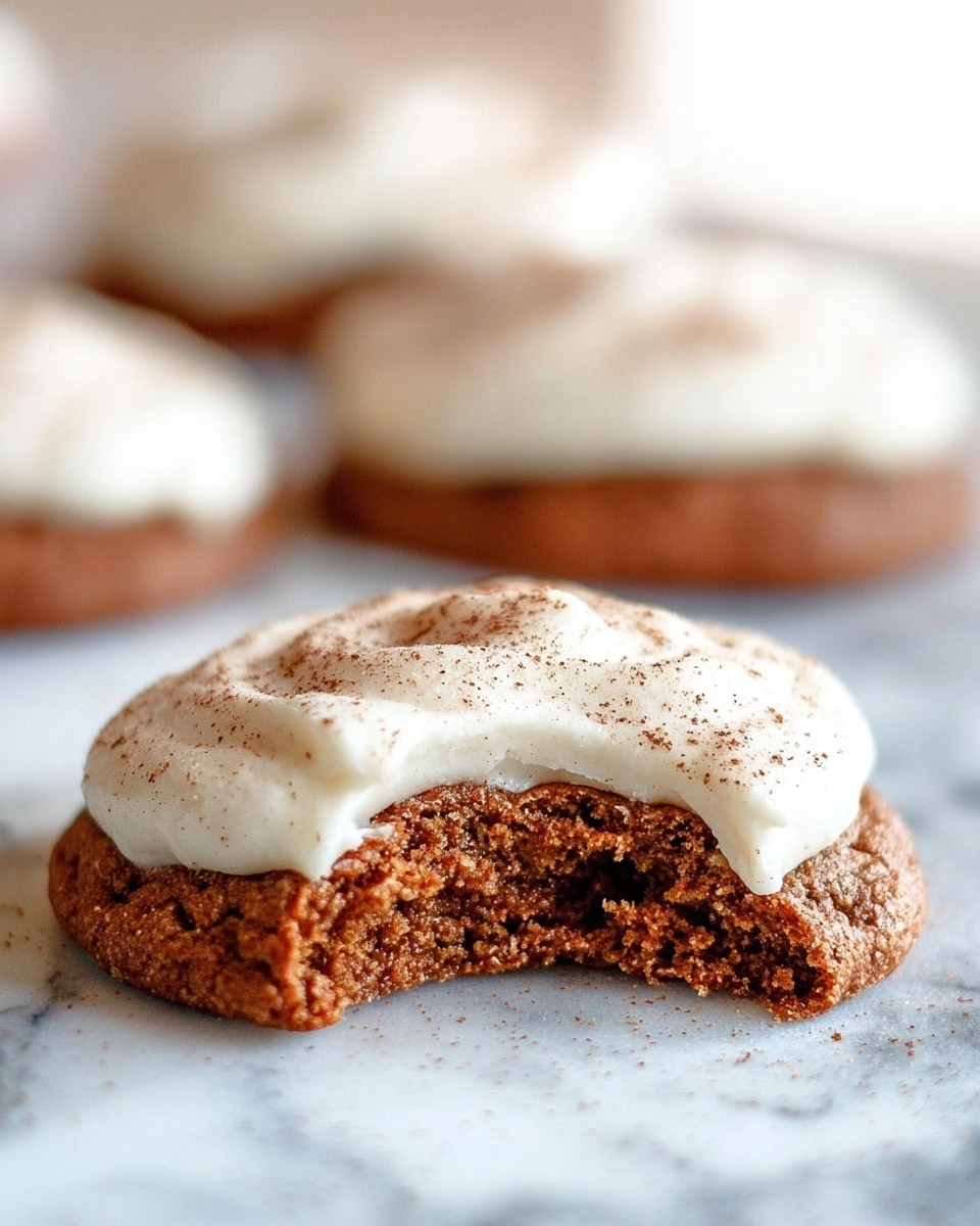The image shows eight round cookies placed on a white marbled surface. Each cookie has a dark brown base layer with a rough texture. On top of each cookie, there is a swirl of creamy white frosting, which appears smooth and thick. Light brown powder, likely cinnamon, is sprinkled over the frosting and the white surface, giving a soft dusted look. The cookies are arranged in a scattered pattern, with the focus on the varied swirls of frosting and the textured cookie bases. photo taken with an iphone --ar 4:5 --v 7