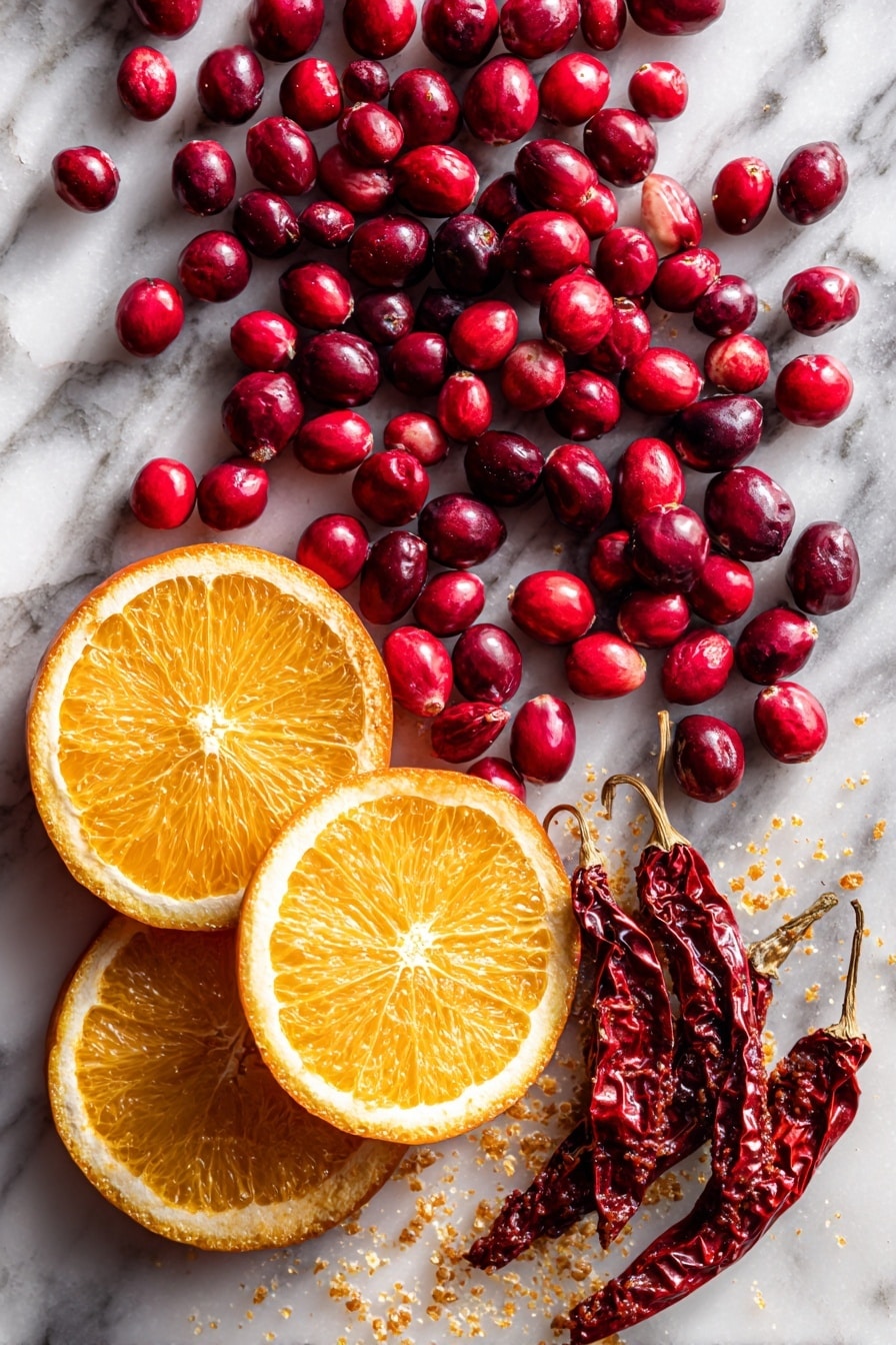 Flat lay of fresh, bright red cranberries with glossy skins scattered next to a small pile of vibrant orange slices showing juicy, textured flesh, deep red dried chipotle peppers with wrinkled surfaces, and a small heap of smoky red adobo sauce glistening, all arranged naturally with a sprinkle of golden sugar crystals catching the light, placed on white marbled surface, photo taken with an iphone --ar 2:3 --v 7 - Chipotle Cranberry Chutney, spicy cranberry chutney, holiday cranberry sauce, smoky cranberry condiment, fruity savory chutney