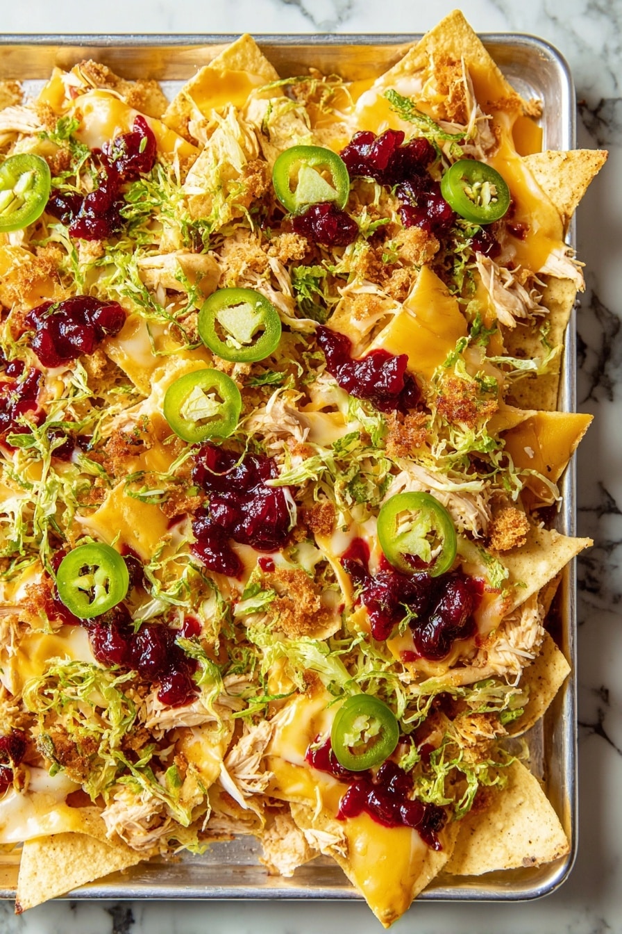 A silver rectangular tray holds a close-up view of nachos arranged in one thick layer of pale yellow tortilla chips. The chips are topped with evenly melted golden-yellow cheddar cheese and scattered shredded light beige turkey pieces. On top of this are small clusters of light brown stuffing crumbs, thin slices of bright green jalapeño rings, and finely chopped green scallions. Light green shredded Brussels sprouts add a fresh touch, while uneven dollops of deep red cranberry sauce are drizzled throughout, creating a contrast of colors and textures against the white marbled surface below. photo taken with an iphone --ar 2:3 --v 7 - Friendsgiving Nachos, Thanksgiving Nachos, Holiday Nachos, Fall Party Snacks, Leftover Nachos