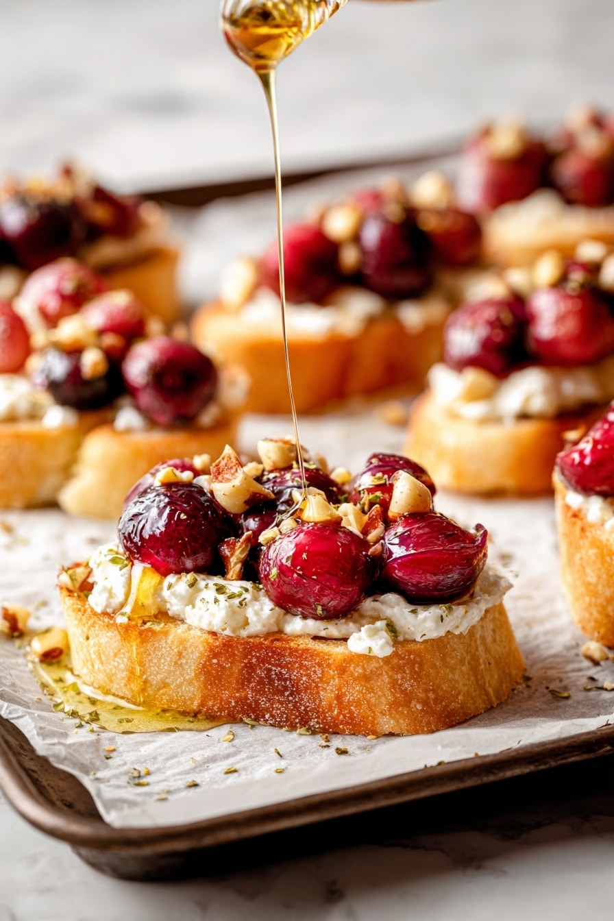 The image shows a tray lined with white parchment paper holding eleven toasted bread slices, each topped with a light golden melted cheese layer. On top of the cheese are clusters of dark red and bright red grapes, sprinkled with small chopped nuts and green herbs. Around the tray, some whole grapes and nuts are scattered, and a small white bowl with honey and a wooden honey dipper rests on the right side. The tray is placed on a white marbled surface. photo taken with an iphone --ar 2:3 --v 7 - Roasted Grape & Brie Crostini with Honey and Sea Salt, roasted grape crostini, brie appetizer, honey and sea salt crostini, elegant grape crostini