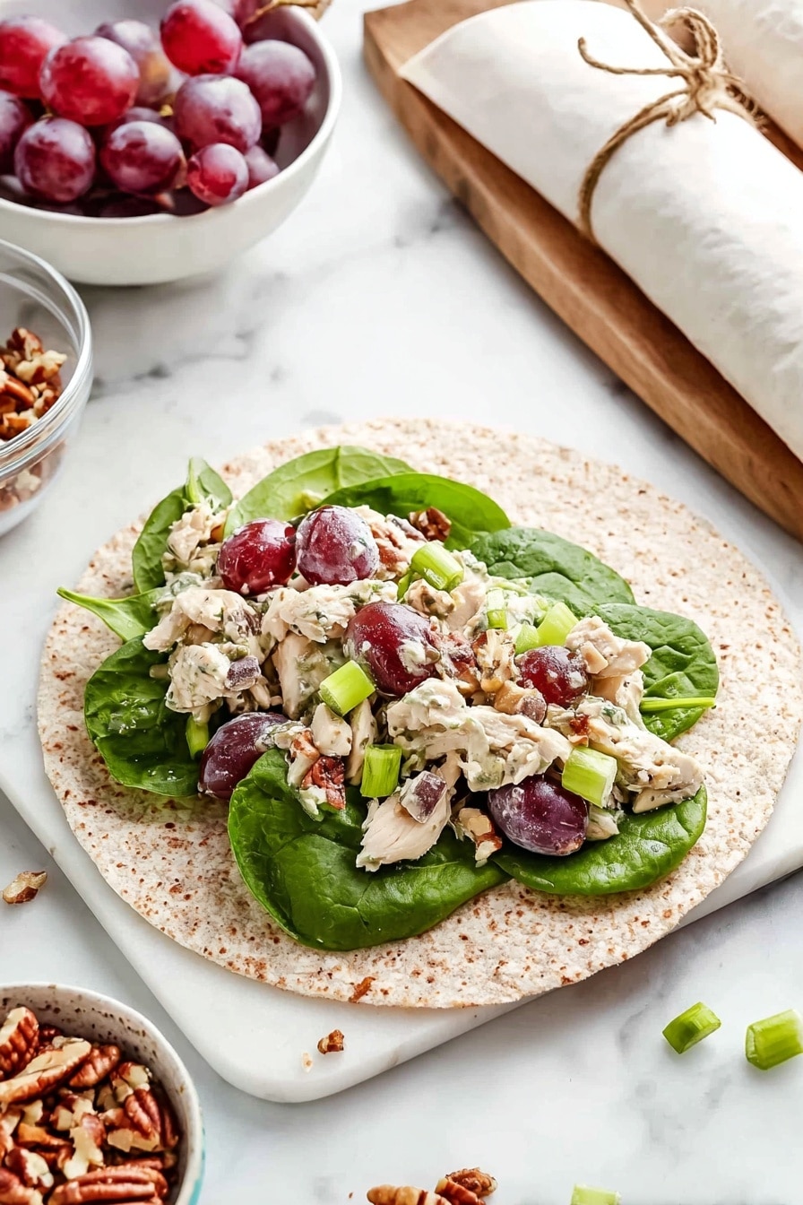 A whole wheat tortilla lies flat on a white marbled surface, layered first with fresh, large dark green spinach leaves, topped with a mix of diced light-colored cooked chicken, halved purple-red grapes, light green crunchy celery slices, and small chopped brown pecans scattered evenly. Bright green sliced scallions add a fresh touch across the filling. In the background, two rolled tortillas tied with white paper strips and brown twine rest on the white marbled surface. Nearby, a clear bowl of chopped pecans, a white bowl of the chicken salad mix, and a small white bowl filled with whole purple-red grapes complete the scene. Photo taken with an iphone --ar 2:3 --v 7 - Healthy Turkey Salad Wrap, Turkey Salad Wrap, Healthy Wrap Recipes, Quick Lunch Ideas, Nutritious Turkey Sandwiches