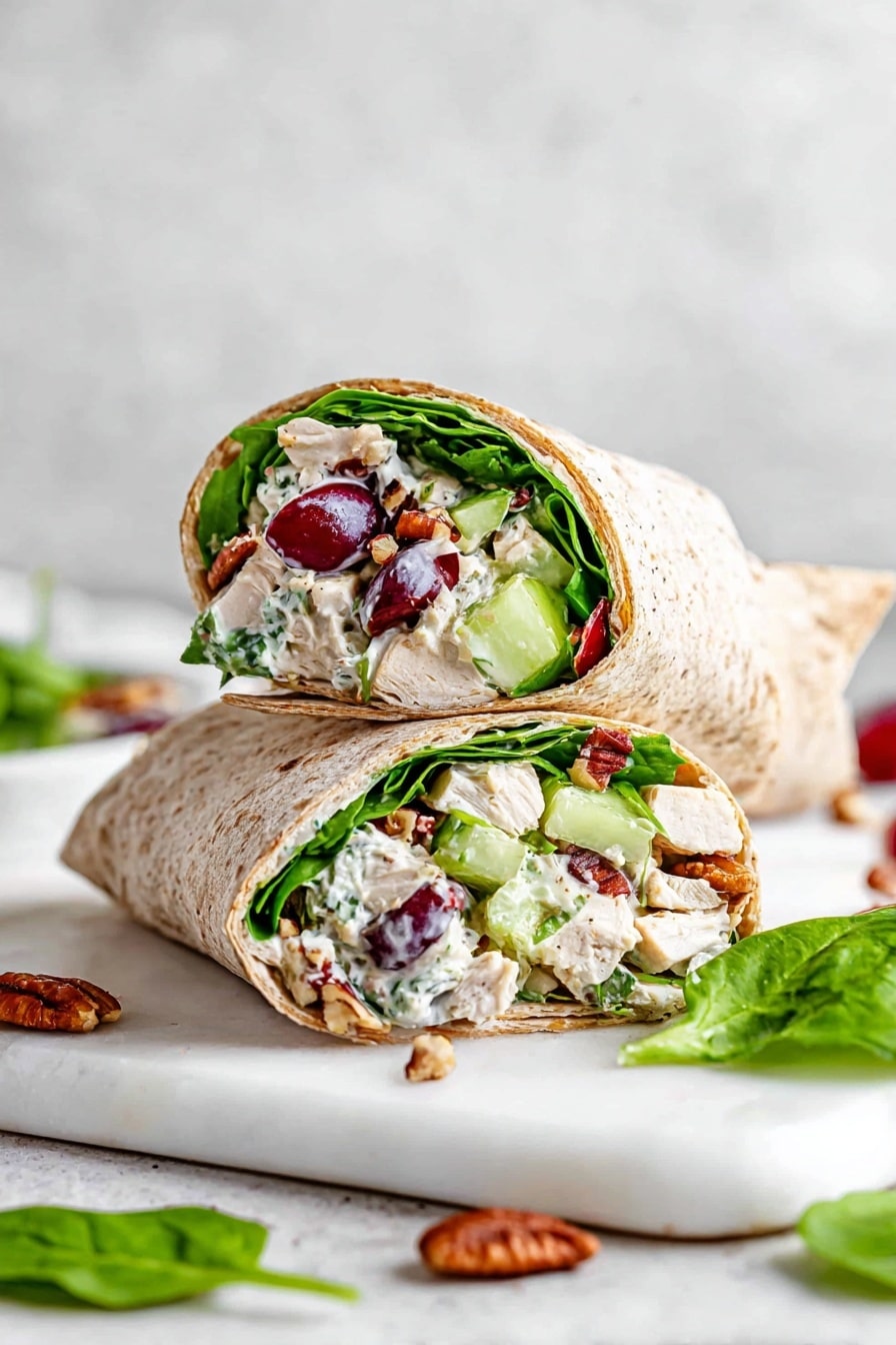 Two halves of a whole wheat wrap are stacked on a white marbled board. The wrap is filled with bright green spinach leaves, chunky pieces of white chicken, red and purple grape halves, light green celery slices, and bits of brown pecans. You can see the soft and creamy white dressing mixed through the filling. Around the board, there are some spinach leaves and pecan pieces scattered. The background is a soft white marbled texture. photo taken with an iphone --ar 2:3 --v 7 - Healthy Turkey Salad Wrap, Turkey Salad Wrap, Healthy Wrap Recipes, Quick Lunch Ideas, Nutritious Turkey Sandwiches