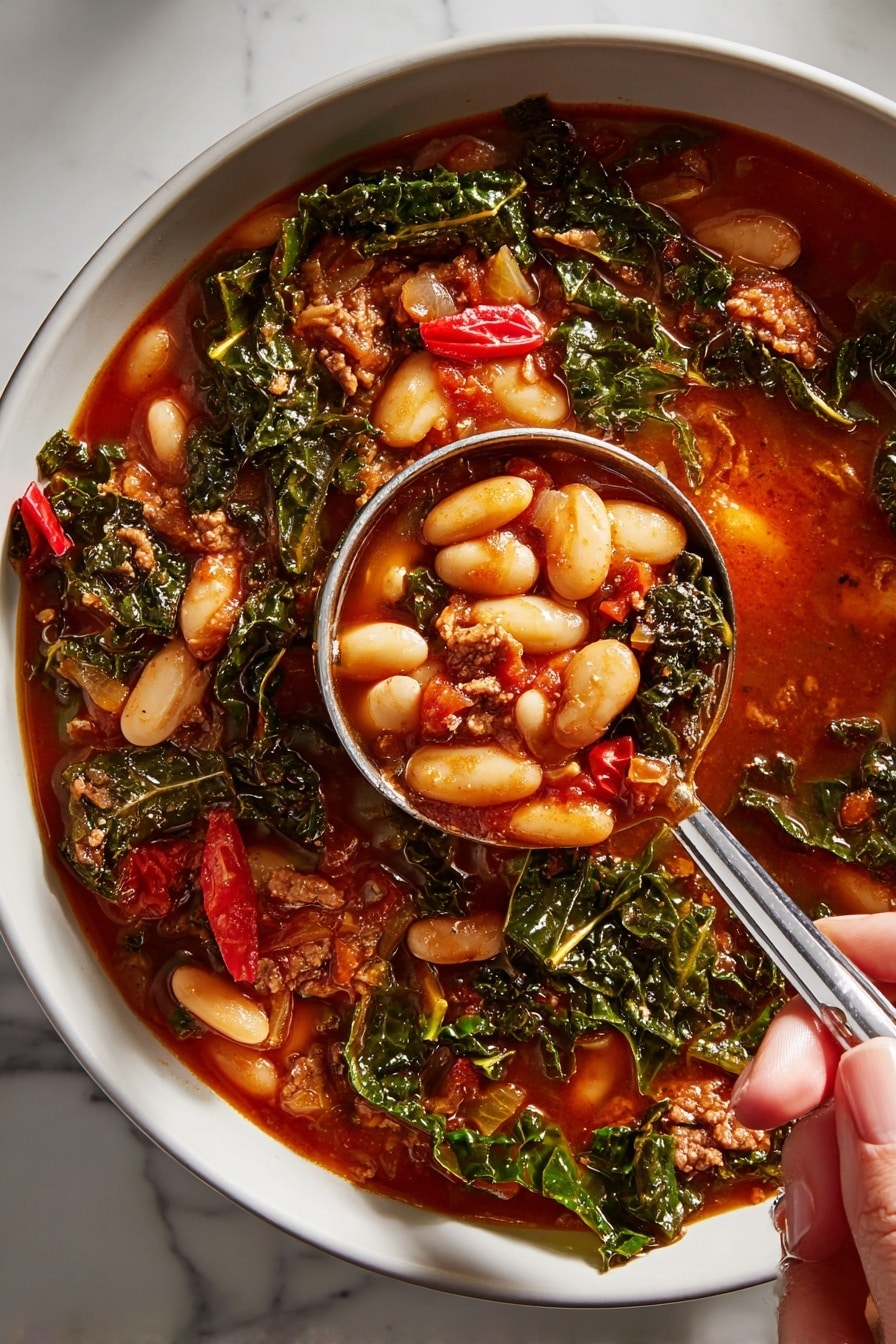 A close-up of a white bowl filled with thick soup, showing three main layers: large white beans with smooth surfaces scattered throughout, a rich dark red tomato-based broth that fills the space around the beans, and dark green kale leaves with a slightly curly texture mixed evenly, along with small pieces of brown cooked meat and some red pepper bits. A metal ladle held by a woman's hand is scooping up some soup from the bowl, capturing a mix of the beans, kale, meat, and broth. The bowl rests on a white marbled surface. photo taken with an iphone --ar 2:3 --v 7 - Spicy Turkey Sausage and Kale Chili, spicy turkey sausage chili, hearty kale chili, healthy turkey sausage chili, easy spicy chili recipe