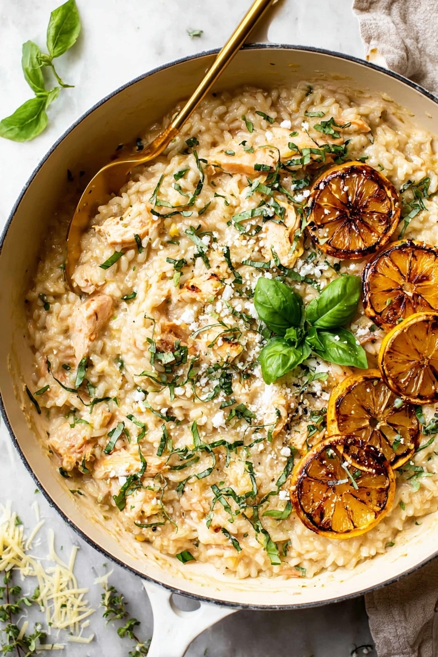 A white speckled bowl holds a creamy, light yellow orzo dish with a soft, thick texture. Within the orzo are small pieces of browned chicken mixed evenly through the creamy pasta. On the top right of the dish, there are two grilled lemon slices with brown char marks and a small cluster of fresh green basil leaves. Scattered over the orzo are small bits of white feta cheese and finely chopped green herbs, adding fresh color contrast. A golden spoon is placed inside the bowl on the left side. The bowl sits on a white marbled surface with scattered basil leaves nearby. Photo taken with an iphone --ar 2:3 --v 7 - Lemon Chicken Orzo Skillet, lemon chicken skillet, lemon chicken dinner, one-pan lemon chicken, citrus chicken orzo