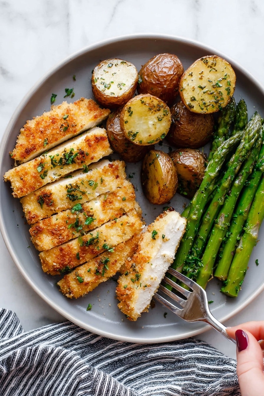 The image shows a round white plate with three sections of food arranged neatly. On the left, there is a piece of breaded chicken cut into several slices with a crispy golden-brown crust and some green herbs sprinkled on top. A woman's hand is holding a fork lifting one slice of the chicken. On the top right, there are round roasted potatoes, golden brown on top with some herbs. On the bottom right, green asparagus spears are placed side by side with a slight shine from cooking. The plate is set on a white marbled surface with part of a striped cloth visible near the bottom edge. photo taken with an iphone --ar 2:3 --v 7 - Crispy Parmesan Garlic Chicken sheet pan, baked chicken dinner, easy chicken sheet pan recipe, garlic parmesan chicken, weeknight chicken recipe