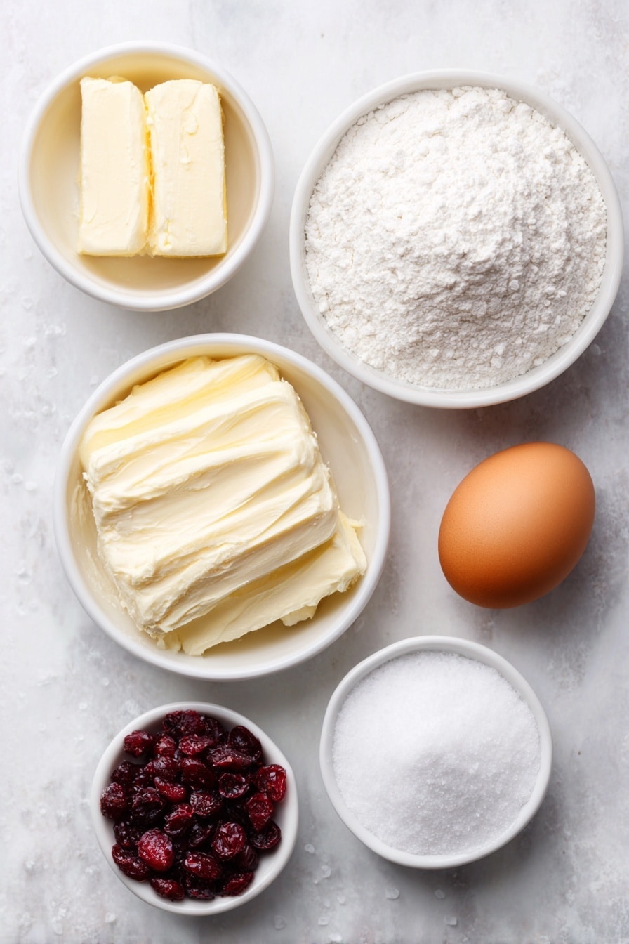 Flat lay of softened unsalted butter in a small white ceramic bowl, a small white bowl filled with smooth white confectioners' sugar, a single whole uncracked brown egg, fresh whole orange with a small pile of bright orange zest beside it, coarse white all-purpose flour arranged in a small white bowl, a small white bowl of chopped dried deep red cranberries, a pinch of coarse salt crystals scattered neatly on the surface, all ingredients spread symmetrically on a clean white marble surface, soft natural light, photo taken with an iPhone, professional food photography style, fresh ingredients, white ceramic bowls, no bottles, no duplicates, no utensils, no packaging --ar 2:3 --v 7 --p m7354615311229779997 - Cranberry Orange Shortbread Cookies, cranberry orange shortbread, citrus cranberry cookies, holiday shortbread cookies, easy fruit shortbread