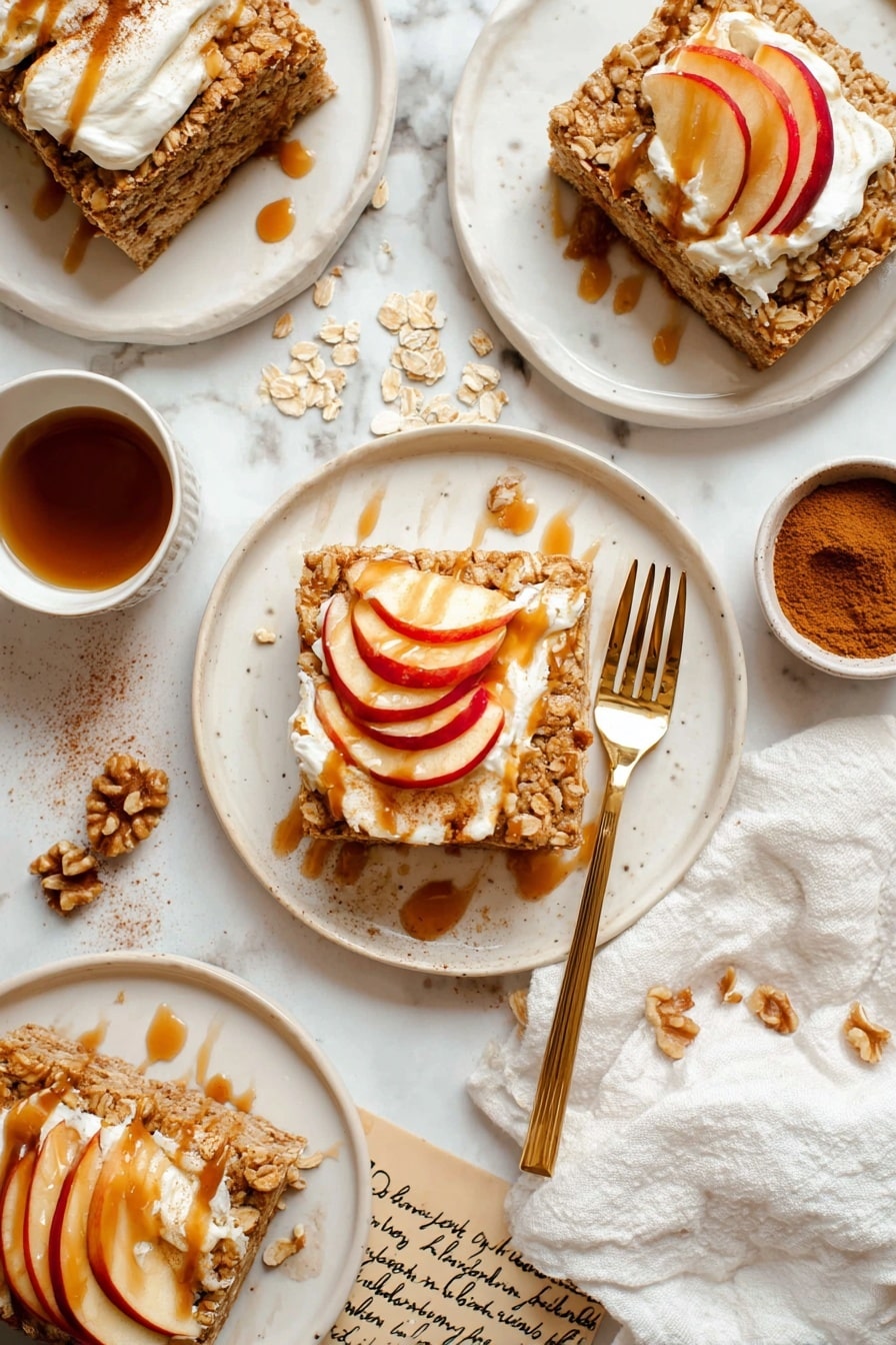 The image shows three white plates each holding a square oatmeal bar topped with a layer of white cream, thinly sliced red apples arranged in a fan shape, and a drizzle of caramel or syrup over the apples and cream. The oatmeal bars have a rough, crumbly texture with visible oats. A gold fork rests on the plate in the center. Around the plates are small white bowls, one containing cinnamon powder and another with caramel sauce, and a bowl with walnut pieces on a white cloth napkin. The background has a white marbled texture with scattered oats and handwritten notes visible beneath the plates. photo taken with an iphone --ar 2:3 --v 7 - Cinnamon Apple Baked Oatmeal, healthy breakfast baked oats, cozy apple cinnamon casserole, nutritious oatmeal dish, easy apple baked oatmeal