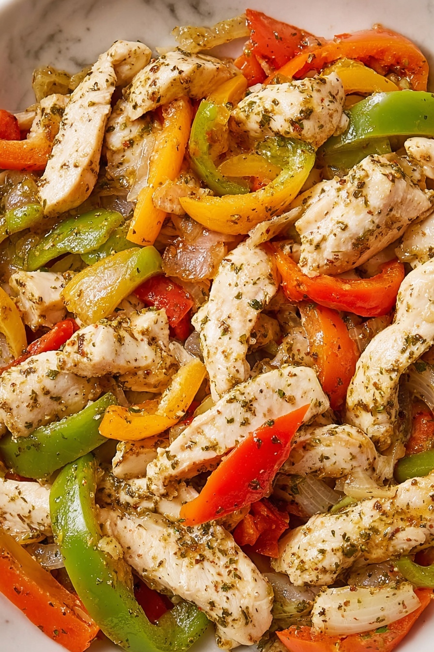 This image shows a close-up view of a dish made of white cooked chicken strips mixed with small pieces of green, yellow, and red bell peppers, with some cooked onions visible. The chicken pieces are seasoned with herbs and spices and have a soft, slightly glossy texture. The vegetables are bright and look tender but firm. The food is shown on a white marbled surface. photo taken with an iphone --ar 2:3 --v 7 - Chicken Cheesesteak Sandwiches, easy chicken sandwiches, quick dinner ideas, flavorful sandwich recipes, cheesy chicken sandwiches