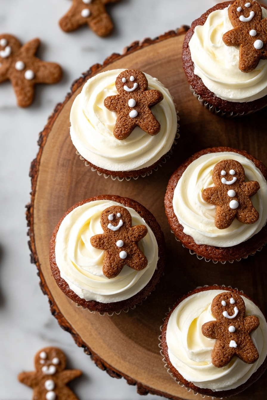 The image shows a group of small brown cupcakes sitting on a white marbled surface. Each cupcake has one layer of whipped white cream on top that looks soft and fluffy. Stuck into the cream of each cupcake is a small brown gingerbread cookie shaped like a person, decorated with small white icing dots for eyes and buttons. Around the cupcakes on the surface are flat gingerbread cookies shaped like stars and gingerbread people, decorated with white icing. The background is blurred and soft beige. photo taken with an iphone --ar 2:3 --v 7 - Gingerbread Cheesecake Bites, festive cheesecake recipes, holiday dessert ideas, gingerbread treats, mini cheesecake bites