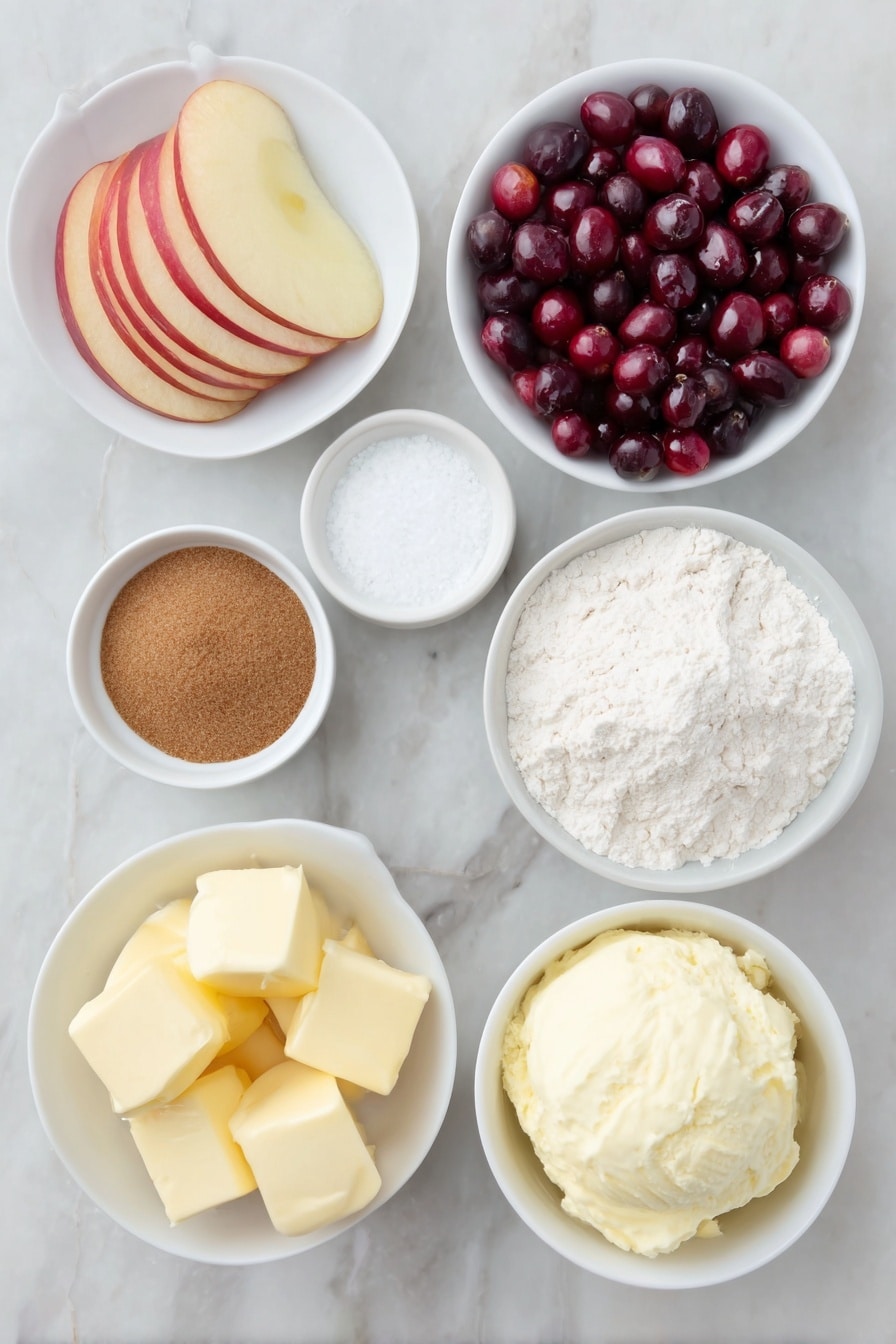 Flat lay of a small pile of fresh cranberries, two peeled and sliced apples arranged in neat overlapping slices, a small white ceramic bowl filled with packed brown sugar, another small white bowl containing ground cinnamon powder, a separate small white bowl holding all-purpose flour, a third small white bowl with clear vanilla extract, a neat mound of all-purpose flour, granulated sugar, baking powder, and salt combined in a simple white bowl, several cubes of cold butter with clean edges placed beside the flour mixture, a small white bowl with thick heavy cream, and a scoop of creamy vanilla ice cream in a white ceramic bowl, all arranged with perfect symmetry and realistic proportions, placed on a clean white marble surface, soft natural light, photo taken with an iPhone, professional food photography style, fresh ingredients, white ceramic bowls, no bottles, no duplicates, no utensils, no packaging --ar 2:3 --v 7 --p m7354615311229779997 - Cranberry Apple Cobbler with Biscuit Topping, cranberry apple dessert, easy fruit cobbler recipe, holiday fruit cobbler, cozy baked fruit dessert