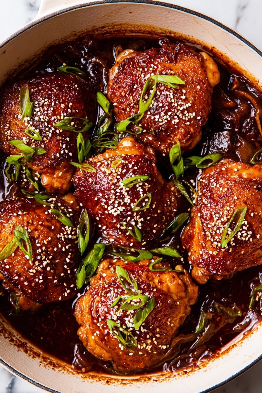 The image shows six browned chicken pieces cooked in a shiny dark sauce inside a white pan. The chicken has a crispy skin layer covered with small white sesame seeds and sprinkled with thin green onion slices on top. The sauce beneath the chicken is thick, glossy, and dark reddish-brown with some caramelized bits on the surface. The pan rests on a white marbled surface, adding a clean and bright contrast to the deep tones of the dish photo taken with an iphone --ar 2:3 --v 7 - Braised Chicken Thighs with Soy Sauce and Ginger, Asian chicken recipes, flavorful chicken dinner ideas, easy braised chicken recipes, comforting poultry dishes