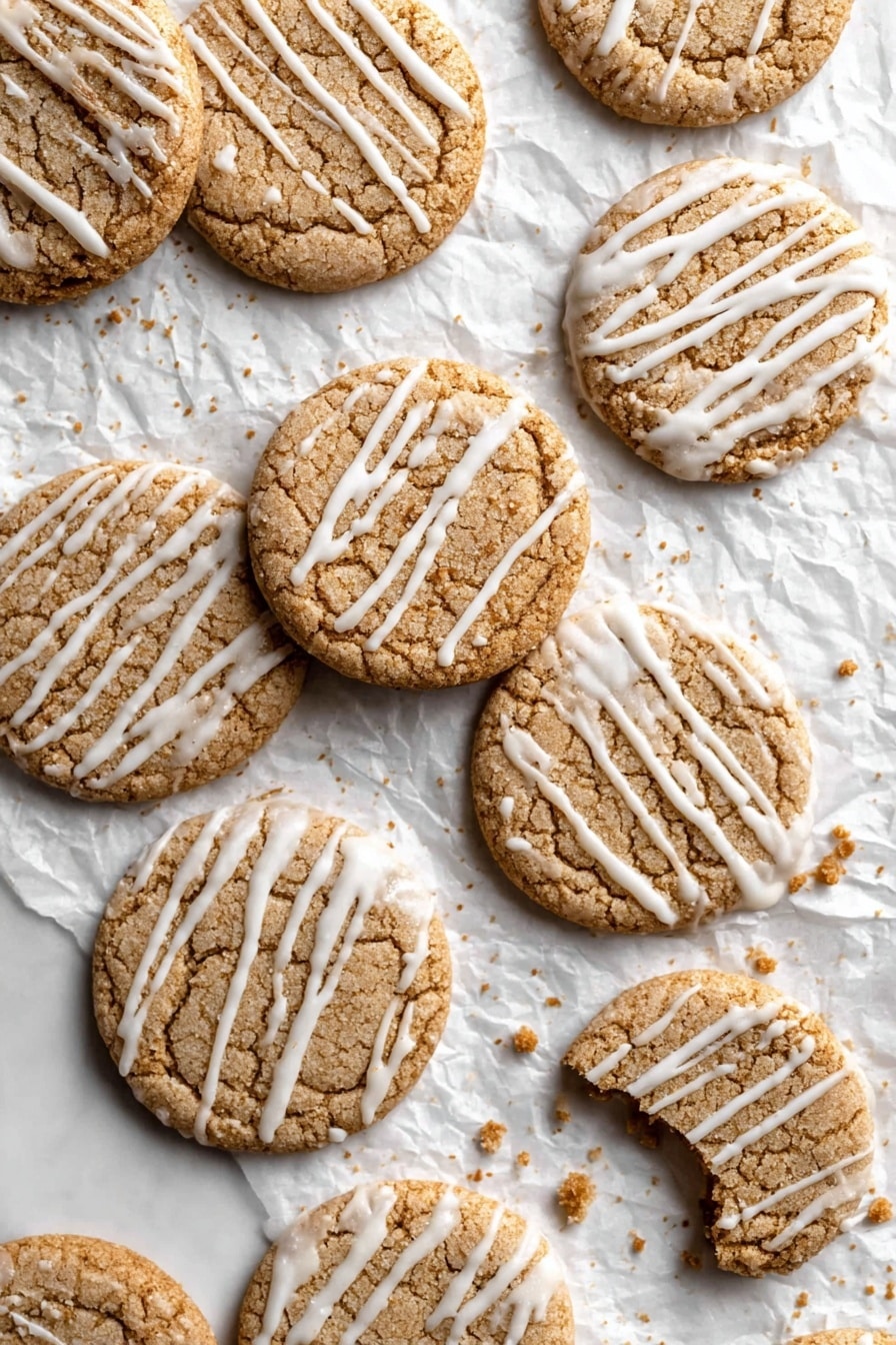 A stack of seven light brown round cookies with white icing drizzle on top is placed on a wire cooling rack over a white marbled surface. The top cookie has a bite taken out of it, showing a soft inside texture. Around the stack, there are a few more cookies with similar icing. In the background, there are two white ceramic Christmas tree decorations and a white ceramic pitcher, softly blurred. The scene is cozy and bright with natural light. photo taken with an iphone --ar 2:3 --v 7 - Eggnog Cookies with Glaze, festive eggnog cookies, holiday cookie recipes, soft chewy cookie recipes, Christmas cookie ideas