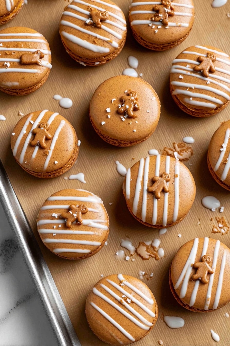 The image shows a dozen round gingerbread-colored macarons placed on brown parchment paper on a metal baking tray. Each macaron has a smooth top with two or three diagonal white icing stripes across one side. Small gingerbread man-shaped sprinkles are scattered on top of the iced stripes. The macarons have two light brown shells with a thin layer of filling inside visible at the edges. Some white icing has dripped slightly onto the parchment paper around the macarons. The background and surface have a white marbled texture. photo taken with an iphone --ar 2:3 --v 7 - Gingerbread Macarons with Molasses Buttercream, holiday gingerbread macarons, spice-filled cookie recipes, DIY festive macarons, homemade holiday treats