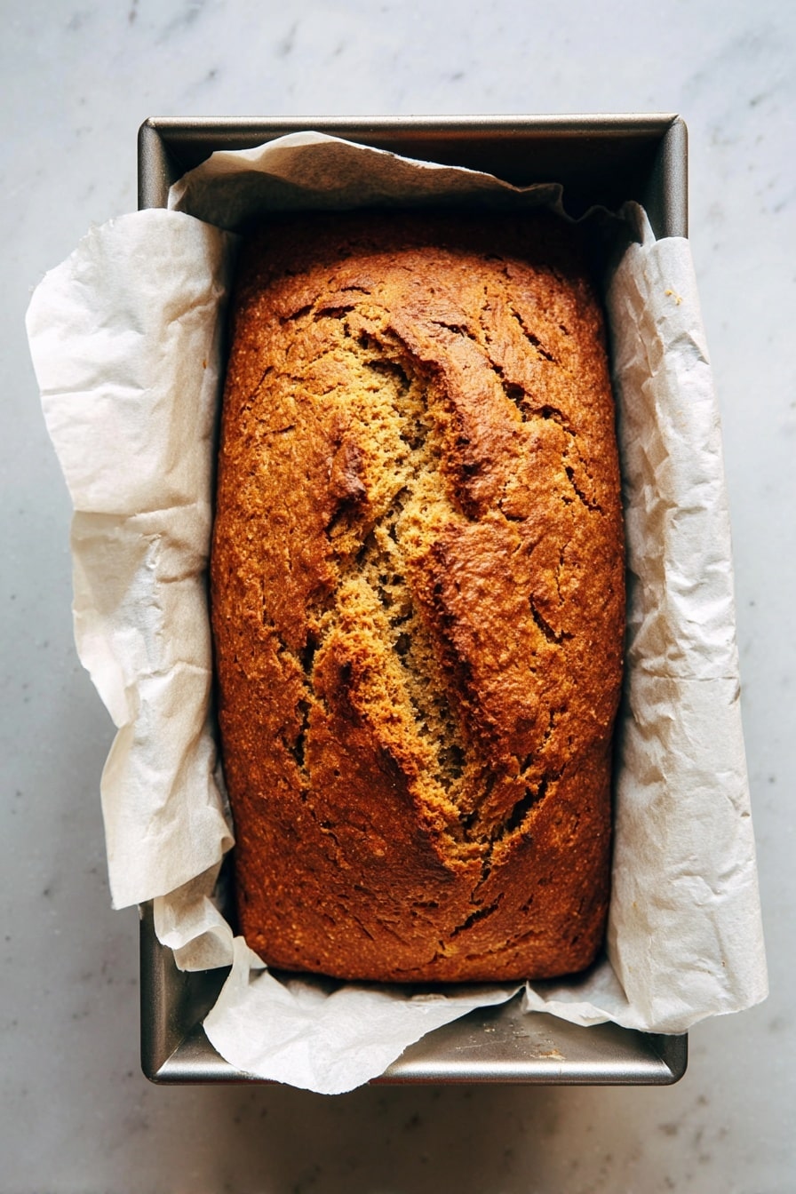 The image shows five thick slices of pumpkin bread with a soft, slightly crumbly texture and a deep orange-brown color. The slices are stacked closely on a round wire cooling rack, which is placed on a beige striped cloth. In the background, there is a whole pumpkin slightly out of focus. The surface underneath is a white marbled texture. The warm, rich color of the bread contrasts nicely with the neutral tones of the cloth and white marbled surface, giving a cozy, autumn feel. photo taken with an iphone --ar 2:3 --v 7 - Best Pumpkin Bread, Pumpkin Bread Recipe, Easy Pumpkin Bread, Moist Pumpkin Loaf, Fall Baking Recipes