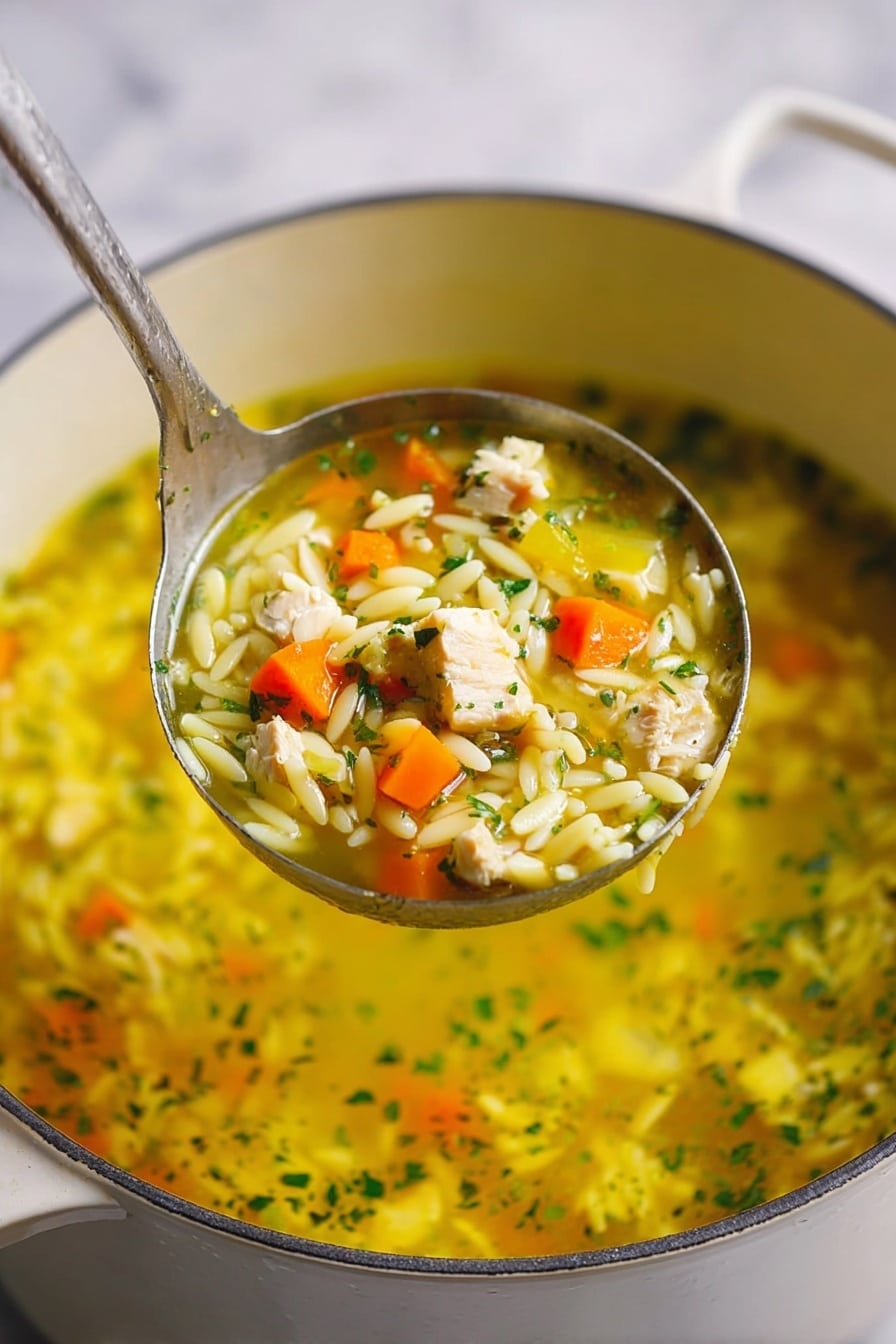 A white bowl filled with yellow broth soup sits on a white plate with small pieces of light yellow pasta pearls, orange carrot cubes, green herbs, and light beige chicken pieces. The soup looks thick with visible fresh chopped green parsley sprinkled on top and around the plate. There are square light brown crackers placed on the right side of the plate. The bowl and plate rest on a white marbled surface with a red cloth blurred in the background. photo taken with an iphone --ar 2:3 --v 7 - Lemongrass Chicken Pasta Soup, Asian-inspired chicken noodle soup, healthy lemongrass soup recipe, comforting chicken and pasta soup, vibrant lemongrass chicken dish