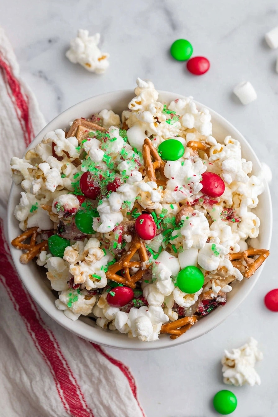 A white bowl filled with a festive popcorn mix sits on a white marbled surface. The mix has visible layers of white popcorn, light brown pretzel pieces, red and green candy-coated chocolates, and small green and red sprinkles scattered on top. The popcorn is glossy with a sticky white coating holding everything together. There are a few candy pieces and tiny white marshmallows scattered around the bowl. In the background, a red, green, and white plaid cloth adds a soft texture to the scene. Photo taken with an iphone --ar 2:3 --v 7 - Festive Christmas Popcorn Snack, Christmas popcorn mix, holiday holiday snack, Christmas party treat, easy Christmas snacks
