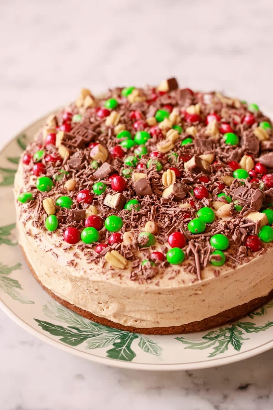 A close-up view of a round cake with three visible layers on a white marbled surface. The bottom layer is dark brown and textured like a dense crust. The middle layer is thicker, light beige with specks, and looks creamy with hints of chocolate chips. The top layer is a lighter, smooth chocolate cream, thicker than the crust but thinner than the middle. The cake top is covered with red and green candy-coated pieces and chunks of chocolate with ridges, creating a colorful, textured topping. The cake has a slice cut out on the right side. Photo taken with an iphone --ar 2:3 --v 7 - Chocolate Mocha Cheesecake, chocolate mocha dessert, coffee flavored cheesecake, decadent chocolate cheesecake, easy mocha cheesecake recipe