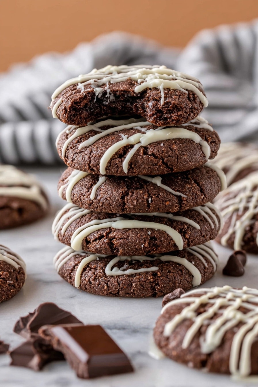 The image shows a close-up of several dark brown chocolate cookies, each topped with thin white icing lines crisscrossing over the surface. The cookies are round with a rough, slightly cracked texture. They are closely placed on a white marbled surface, scattered with a few dark chocolate and white chocolate chips around them. The contrast between the dark cookie base and the bright white icing makes the cookies look more decorative and rich. photo taken with an iphone --ar 2:3 --v 7 - Chocolate Cake Mix Cookies, easy chocolate cookie recipe, fudgy cookies with cake mix, chewy chocolate cookies, simple dessert recipes