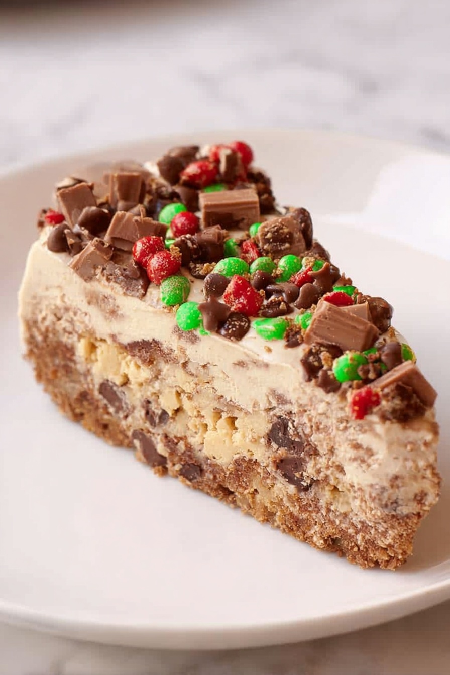 A slice of a multi-layered dessert is shown on a white plate. The bottom layer is brown with a slightly rough texture, resembling a crispy base with bits of nuts or chocolate. Above that is a thick layer of creamy, pale beige filling mixed with darker pieces, giving it a textured look. The top layer is light brown and smooth, like chocolate mousse, decorated with small green and red candy-coated pieces and chunks of chocolate scattered on the surface. The background has a soft, white marbled texture. Photo taken with an iphone --ar 2:3 --v 7 - Chocolate Mocha Cheesecake, chocolate mocha dessert, coffee flavored cheesecake, decadent chocolate cheesecake, easy mocha cheesecake recipe