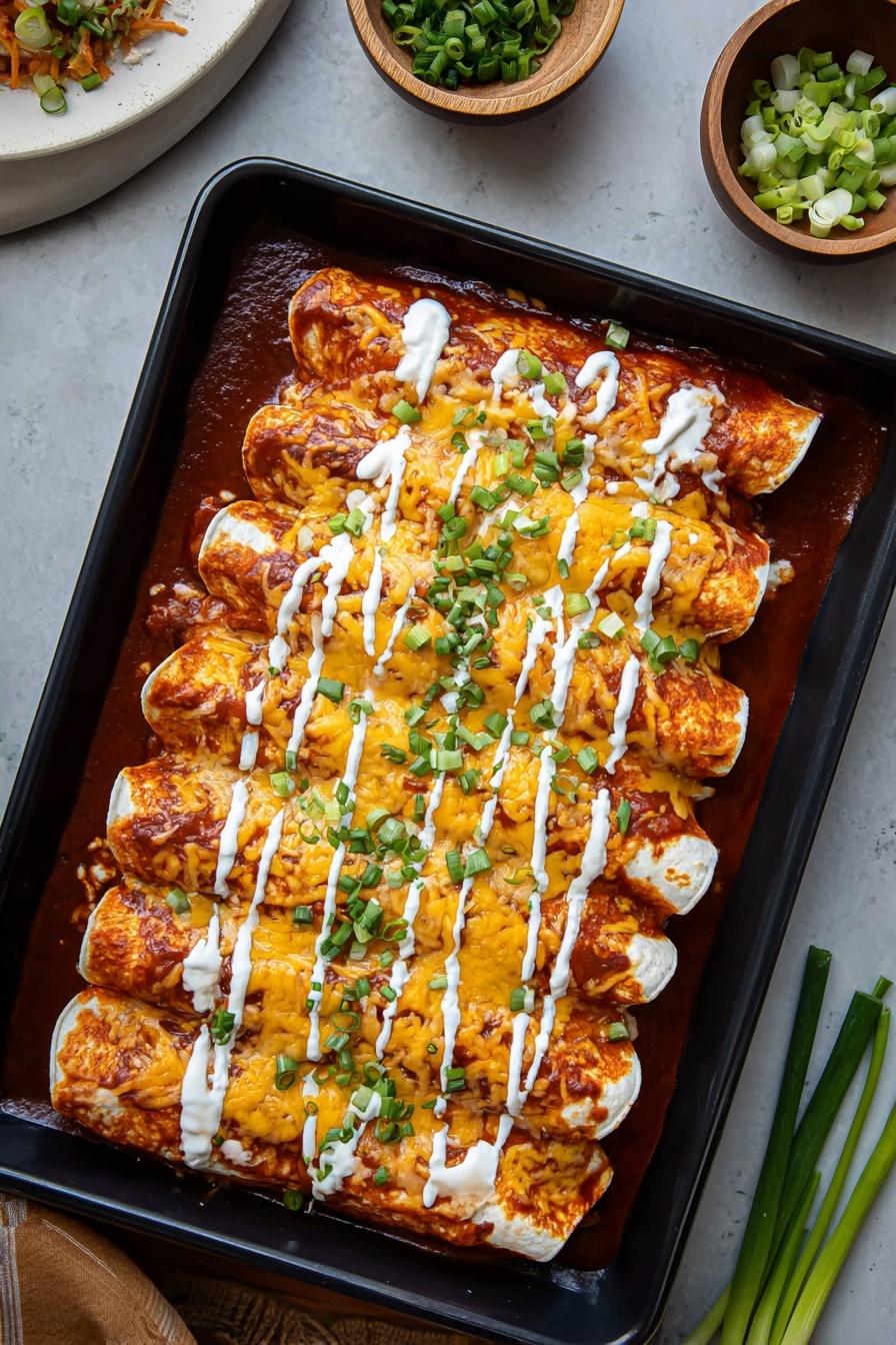 Two enchiladas covered with orange cheese and bright red sauce sit on a white plate. The enchiladas have a soft, light beige tortilla outer layer wrapped around shredded light-colored chicken filling. The top layer shows melted cheese mixed with bits of chicken and sauce, drizzled with white sour cream sauce. Bright green chopped scallions are scattered over the top, adding a fresh color contrast. Sauce pools slightly on the plate around the edges under the enchiladas, which sit on a white marbled textured surface. Photo taken with an iphone --ar 2:3 --v 7 - Buffalo Chicken Enchiladas, spicy chicken enchiladas, cheesy Buffalo chicken casserole, quick chicken enchiladas, easy Tex-Mex dinner