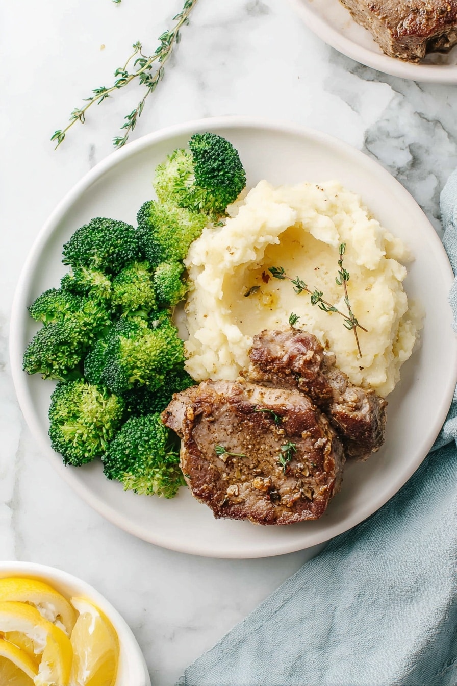 The image shows a cooked meat roast on a white oval platter, partially sliced to reveal three thick, light brown, juicy layers inside. The top layer is dark and crispy with visible herbs and garlic, giving it a textured, seasoned look. Around the roast, there are green rosemary sprigs and fresh thyme adding green accents. Two lemon slices, bright yellow with visible seeds, are placed near the roast. The platter is on a white marbled surface, and in the background, there is a white bowl with more lemon halves. The scene is well-lit, making the roast look moist and flavorful. photo taken with an iphone --ar 2:3 --v 7 - Juicy Roast Boneless Lamb Leg, roasted lamb recipes, tender lamb roast, lemon herb lamb, Sunday dinner lamb