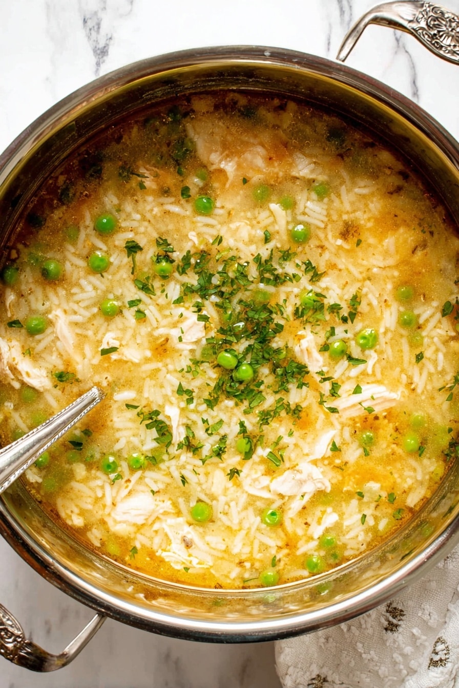 The image shows two white bowls filled with a creamy soup made of rice, green peas, and small pieces of chicken. The soup has a warm yellowish color with a soft texture mixed with white rice grains and bright green peas spread evenly inside. Small green chives are sprinkled on top of the soup, adding a fresh touch and color contrast. The bowls are set on a white marbled surface with some green chive strands and an old-fashioned silver spoon beside the top bowl. The lighting is bright and natural, making the soup look warm and inviting. photo taken with an iphone --ar 2:3 --v 7 - Lemon Chicken Rice Soup, Lemon Chicken Soup, Healthy Chicken Soup, Easy Lemon Soup, Comforting Chicken and Rice Soup