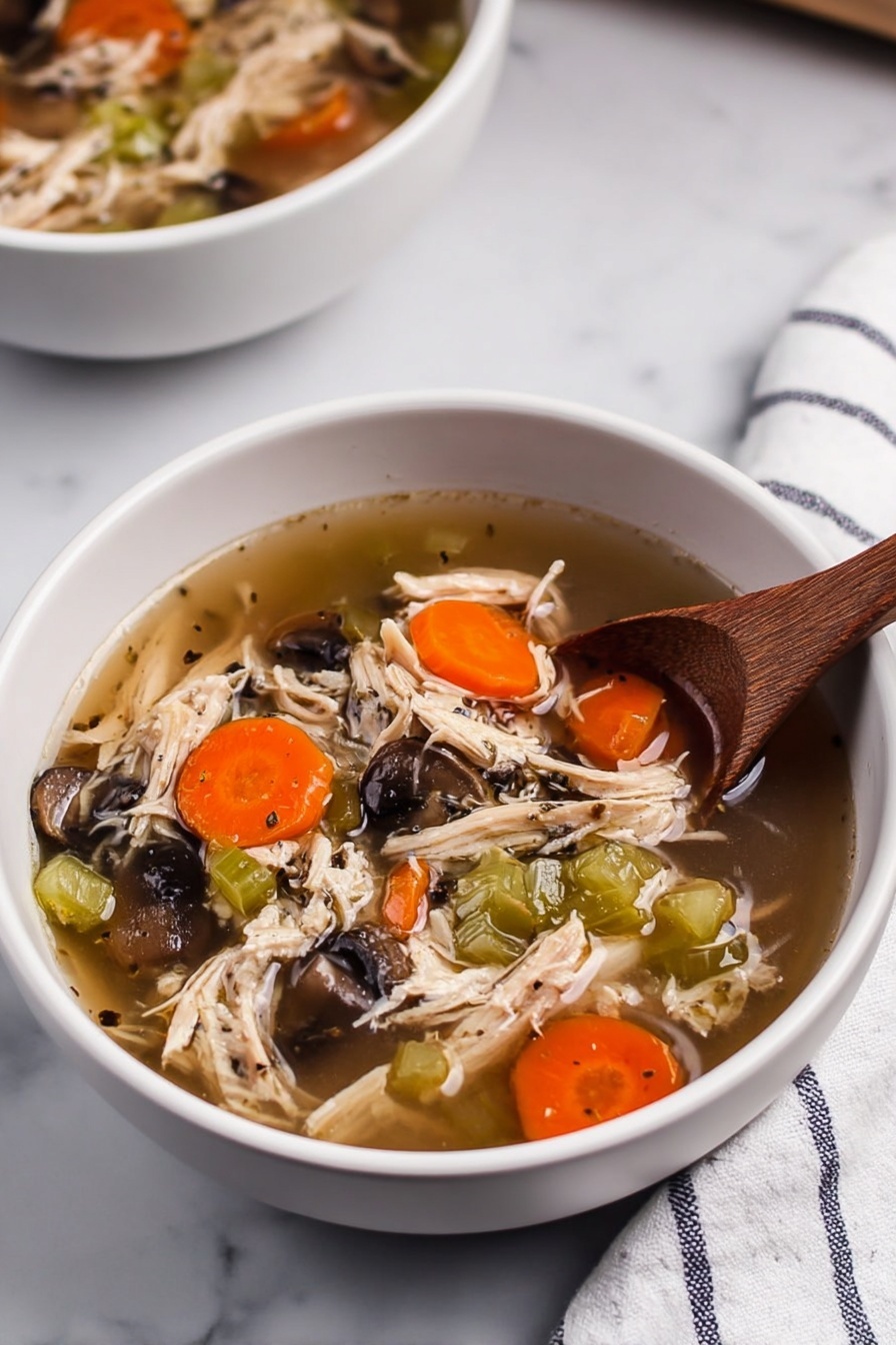 This image shows a black slow cooker filled with a soup that has three main layers. The bottom layer is a clear broth with oil specks that hold the soup together. The middle layer includes bright orange carrot slices and dark brown mushroom pieces scattered well. The top layer has shredded white chicken mixed with small green celery pieces, evenly spread across the soup. A shiny metal ladle is placed inside the slow cooker. Next to it, there are two small white stacked bowls with wooden spoons inside, all set on a white marbled surface with a white cloth that has blue stripes. Photo taken with an iphone --ar 2:3 --v 7 - Slow Cooker Turkey and Rice Soup, turkey and rice soup, easy slow cooker soup, healthy turkey soup, hearty rice soup